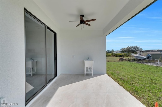 view of patio with ceiling fan and a sink