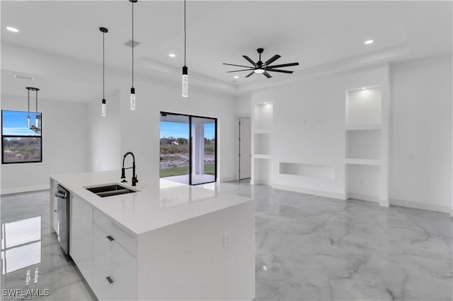 kitchen with recessed lighting, a wealth of natural light, a raised ceiling, stainless steel dishwasher, and a sink