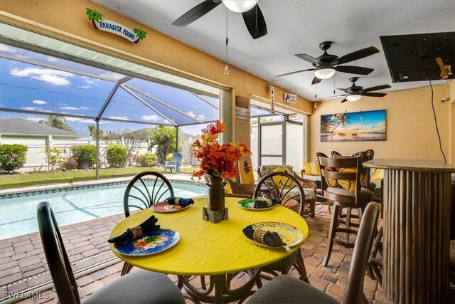 605 SE 22nd St, Cape Coral, FL 33990 - dining room featuring stone tile flooring, a ceiling fan, and a sunroom