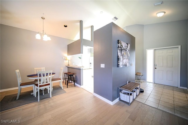 25431 Fairway Dunes Ct, Bonita Springs, FL 34135 - foyer featuring a notable chandelier, baseboards, visible vents, high vaulted ceiling, and wood finished floors
