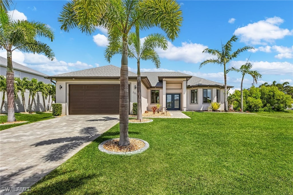 view of front of house with stucco siding, decorative driveway, a garage, and french doors