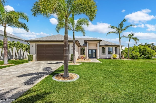 view of front of house with stucco siding, decorative driveway, a garage, and french doors