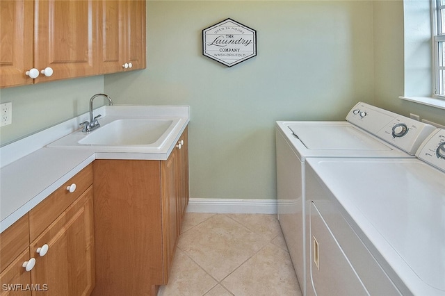 5600 Chelsey Ln Unit 201, Fort Myers, FL 33912 - clothes washing area featuring light tile patterned flooring, washing machine and clothes dryer, a sink, baseboards, and cabinet space