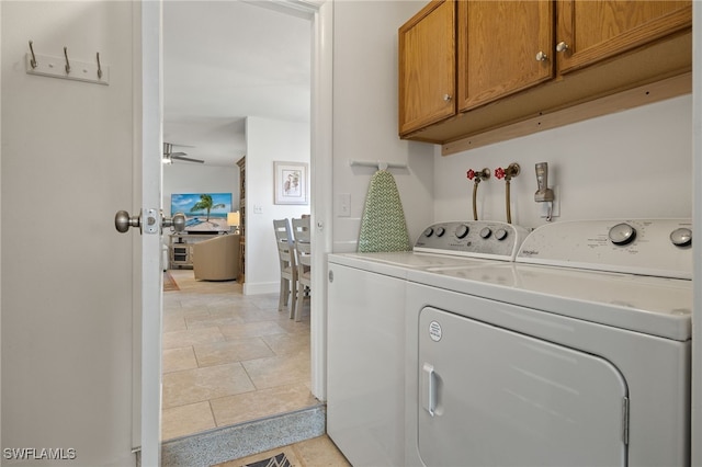 laundry area with light tile patterned floors, ceiling fan, cabinet space, and washer and dryer