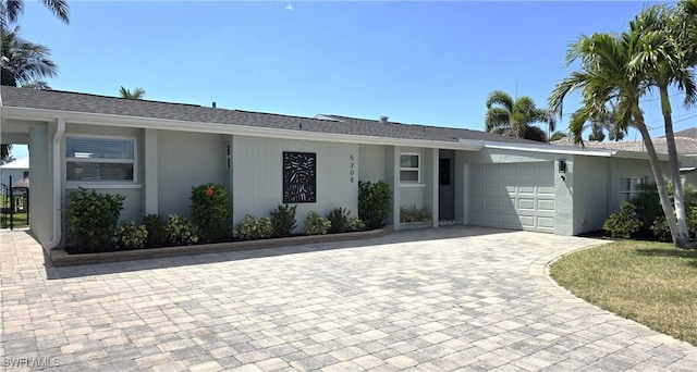 ranch-style house featuring a garage, stucco siding, and driveway