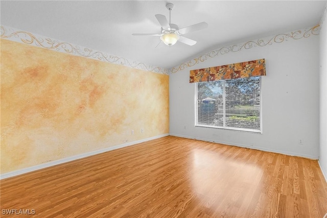 unfurnished room with wood finished floors, baseboards, a ceiling fan, and vaulted ceiling