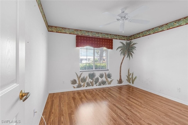 unfurnished room featuring wood finished floors, baseboards, and a ceiling fan