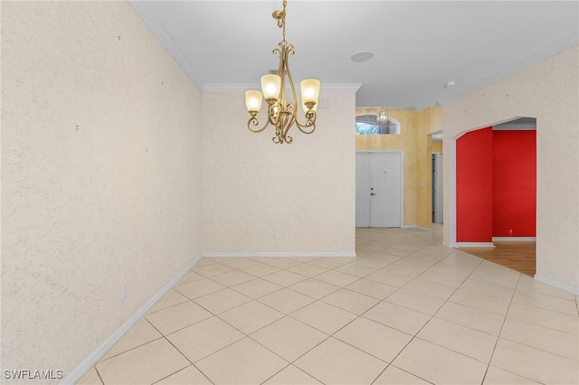 spare room featuring ornamental molding, baseboards, a chandelier, and light tile patterned floors