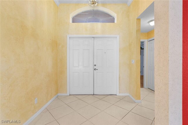 foyer entrance featuring tile patterned flooring and baseboards