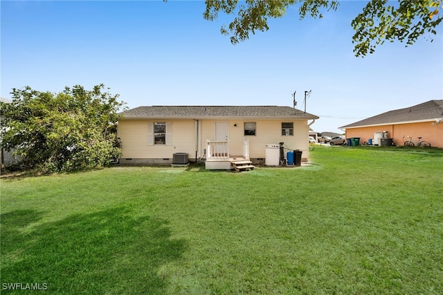 rear view of property with central AC, crawl space, and a lawn