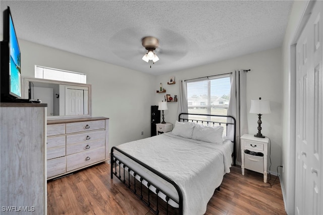 bedroom with wood finished floors, a textured ceiling, and a ceiling fan