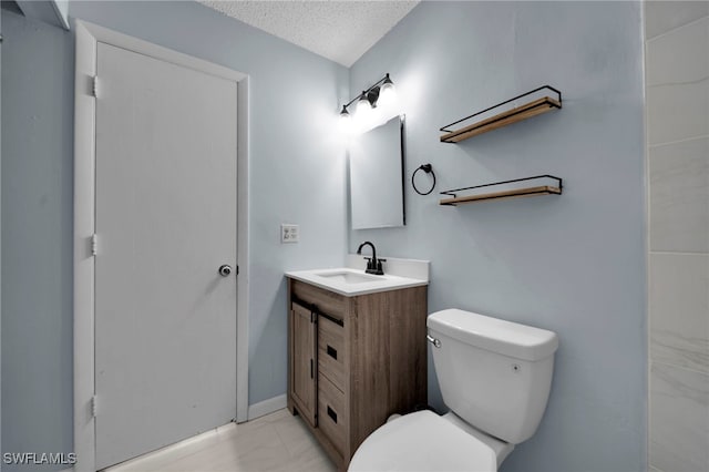 bathroom featuring toilet, marble look tiles, vanity, and a textured ceiling