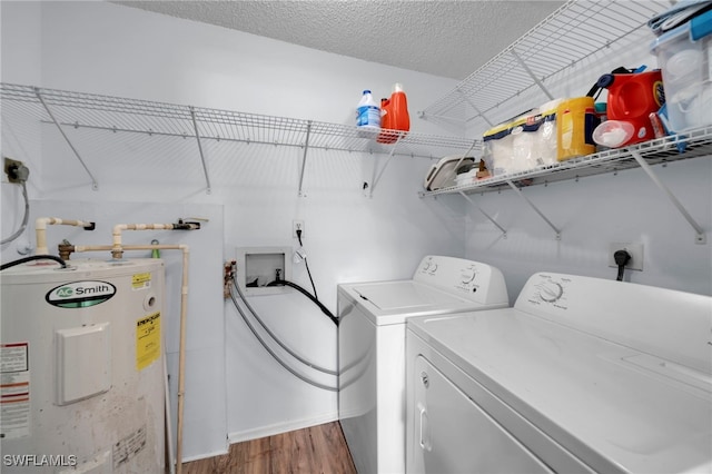 clothes washing area with water heater, wood finished floors, independent washer and dryer, baseboards, and a textured ceiling