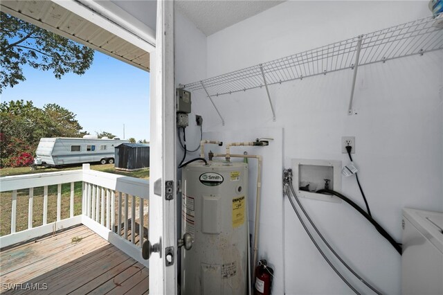washroom with water heater, wood finished floors, and washer / clothes dryer