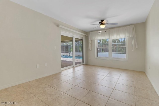 unfurnished room featuring a ceiling fan, tile patterned floors, and baseboards