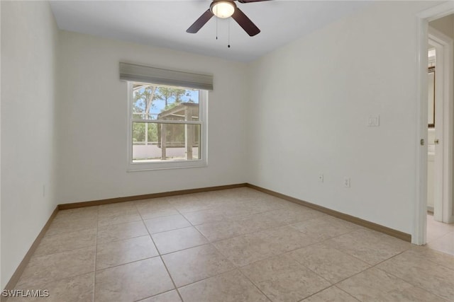 spare room with a ceiling fan, baseboards, and light tile patterned floors