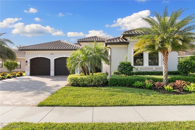 4455 Caldera Cir, Naples, FL 34119 - mediterranean / spanish house with stucco siding, a tile roof, decorative driveway, a front yard, and a garage