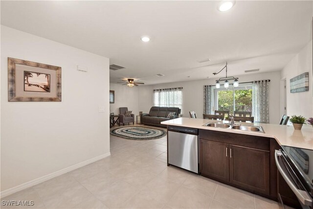 kitchen with dark brown cabinetry, light countertops, visible vents, appliances with stainless steel finishes, and a sink