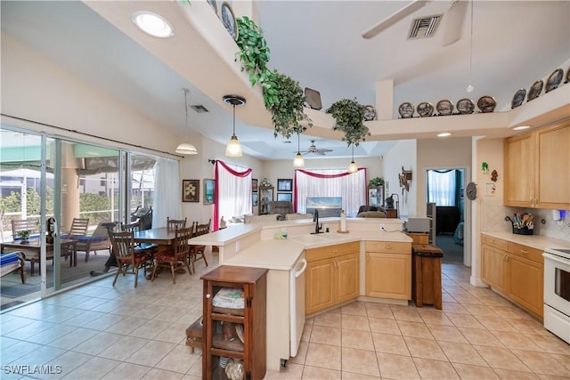 kitchen featuring light tile patterned flooring, light brown cabinetry, a sink, and visible vents