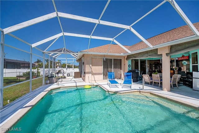 view of pool with glass enclosure, a fenced in pool, a patio, and fence