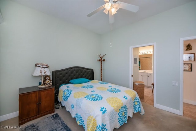 carpeted bedroom featuring ensuite bath, a ceiling fan, and baseboards