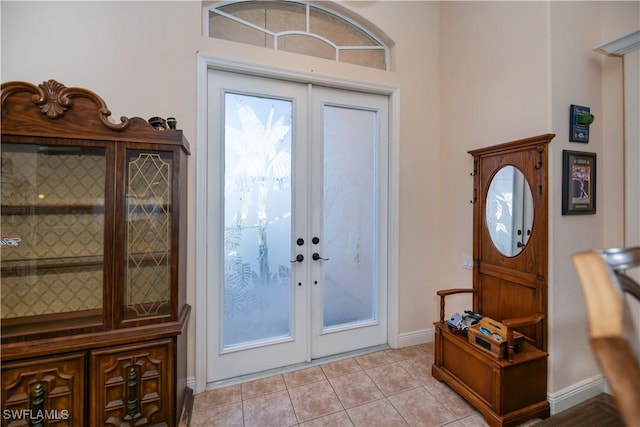 entryway with baseboards, light tile patterned flooring, and french doors