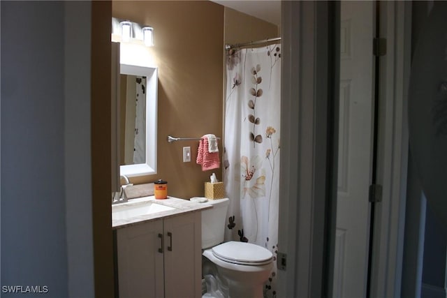 full bath featuring toilet, a shower with shower curtain, and vanity
