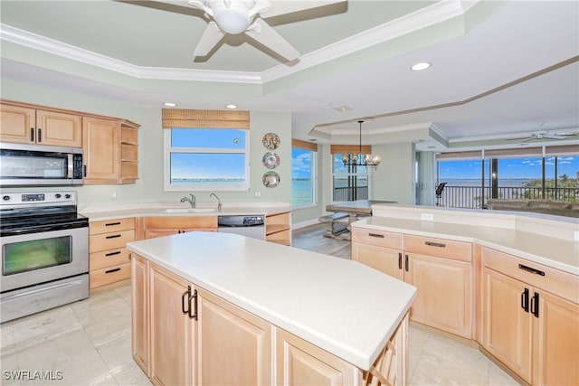 15220 Portside Dr Unit 301, Fort Myers, FL 33908 - kitchen featuring ceiling fan with notable chandelier, stainless steel appliances, light brown cabinets, and a raised ceiling