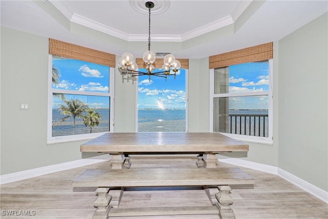 15220 Portside Dr Unit 301, Fort Myers, FL 33908 - dining room with a raised ceiling, wood finished floors, ornamental molding, and an inviting chandelier