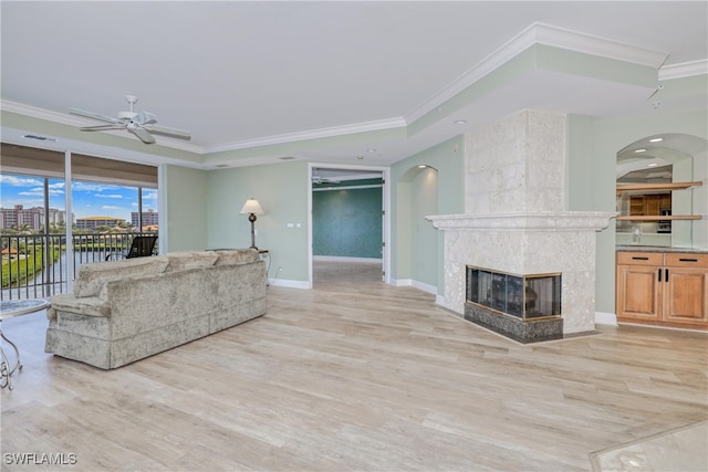 15220 Portside Dr Unit 301, Fort Myers, FL 33908 - living room featuring arched walkways, light wood-type flooring, ceiling fan, crown molding, and a fireplace