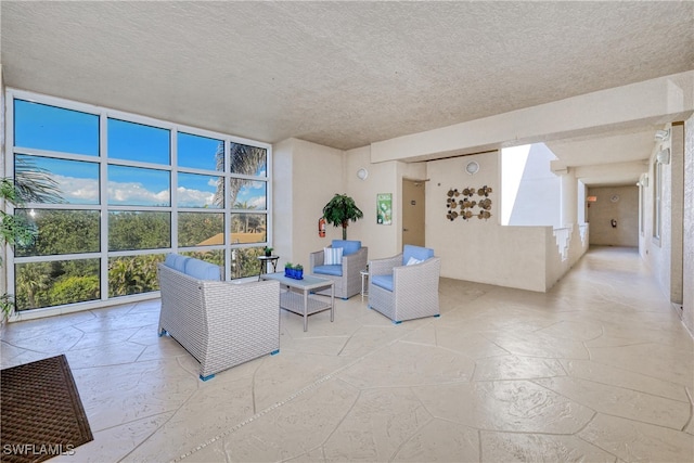 15220 Portside Dr Unit 301, Fort Myers, FL 33908 - living room featuring expansive windows, stone tile flooring, and a textured ceiling