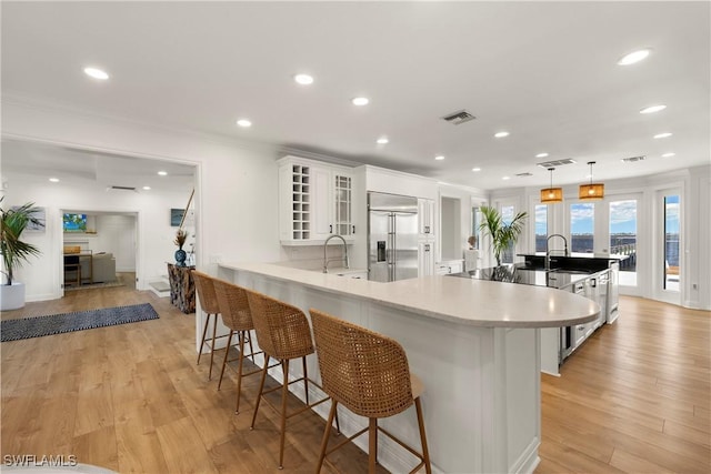 8451 Casa Del Rio Ln, Fort Myers, FL 33919 - kitchen with a kitchen breakfast bar, white cabinetry, visible vents, recessed lighting, and stainless steel built in fridge