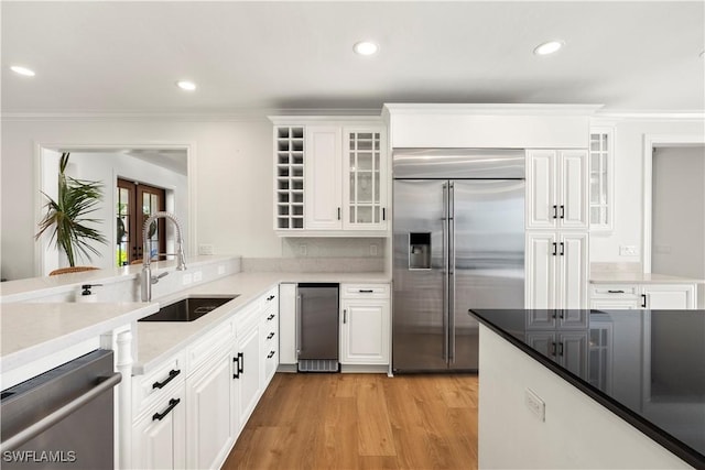 8451 Casa Del Rio Ln, Fort Myers, FL 33919 - kitchen with a sink, white cabinets, light wood-style floors, and stainless steel appliances