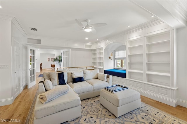 8451 Casa Del Rio Ln, Fort Myers, FL 33919 - living room with visible vents, built in shelves, ornamental molding, ceiling fan, and light wood-style flooring