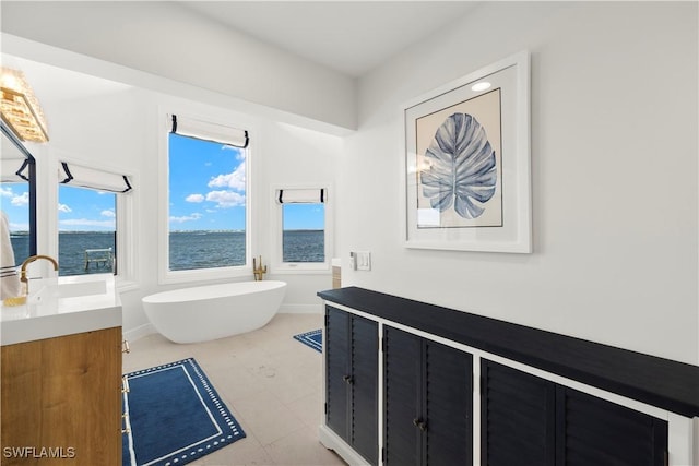 8451 Casa Del Rio Ln, Fort Myers, FL 33919 - full bathroom with a freestanding bath, vanity, a water view, and a healthy amount of sunlight