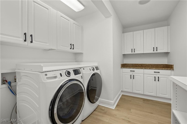 8451 Casa Del Rio Ln, Fort Myers, FL 33919 - clothes washing area with cabinet space, washer and clothes dryer, baseboards, and light wood-style flooring
