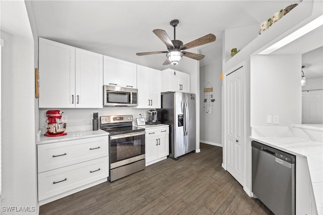 kitchen with white cabinets, dark wood-style flooring, ceiling fan, light stone counters, and appliances with stainless steel finishes
