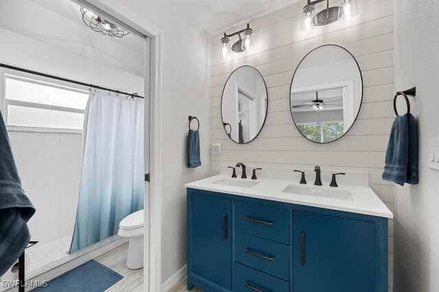 bathroom with toilet, a sink, double vanity, and a tile shower