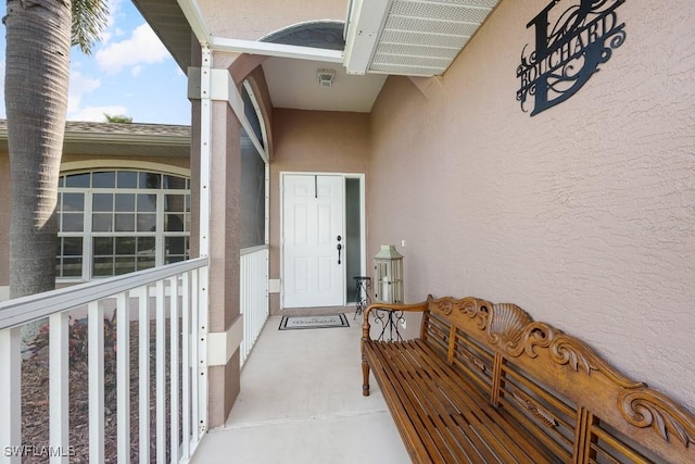 doorway to property featuring stucco siding