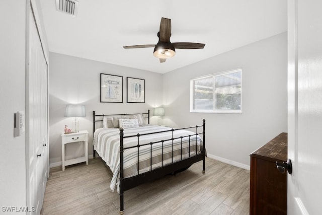 bedroom with ceiling fan, baseboards, light wood-style floors, and visible vents