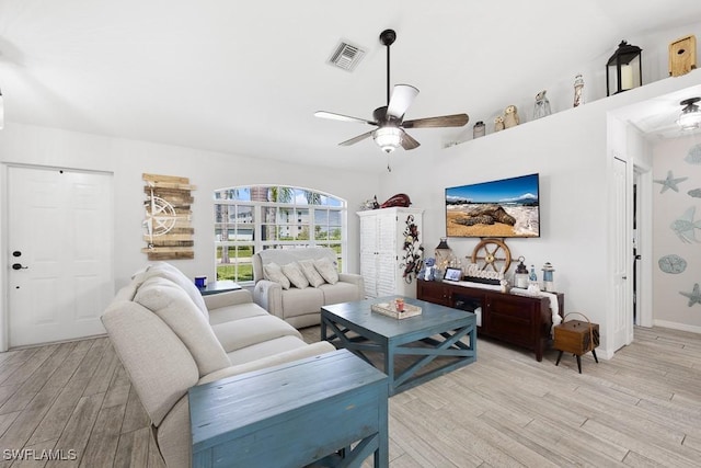 living room featuring light wood-style floors, visible vents, a ceiling fan, and baseboards