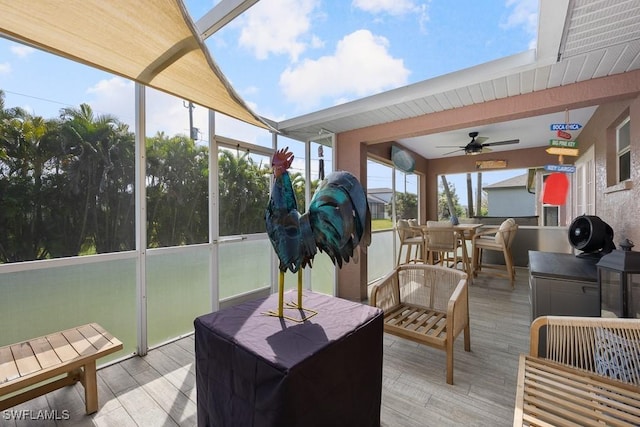 sunroom / solarium featuring ceiling fan and outdoor dining area