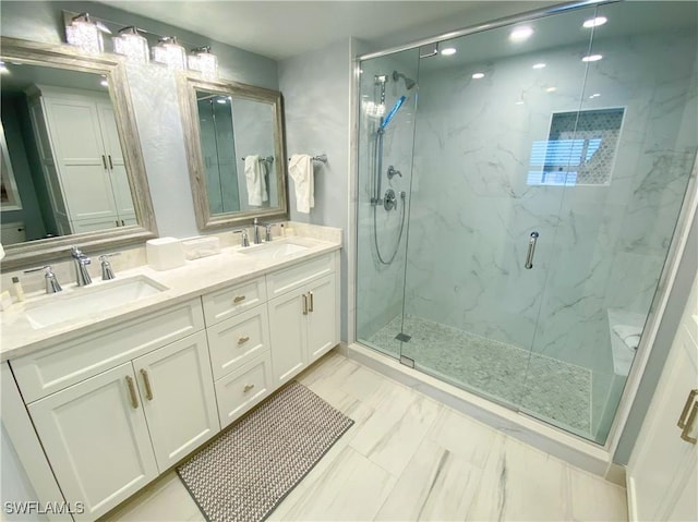 bathroom with marble finish floor, a sink, a marble finish shower, and double vanity