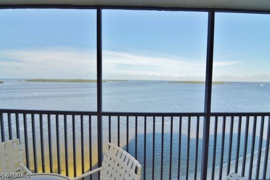 sunroom / solarium featuring a water view