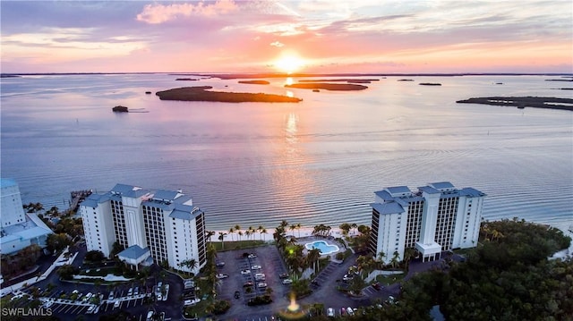 aerial view at dusk featuring a water view