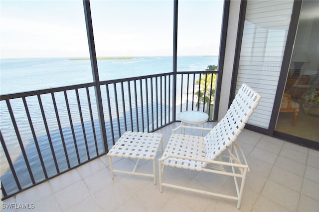 balcony featuring a view of the beach and a water view
