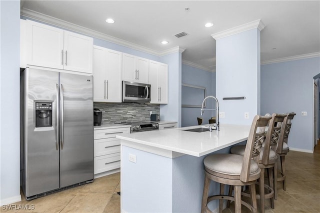 9719 Acqua Ct Unit 241, Naples, FL 34113 - kitchen with stainless steel appliances, a sink, tasteful backsplash, a kitchen breakfast bar, and white cabinets