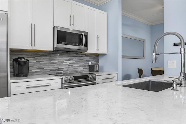9719 Acqua Ct Unit 241, Naples, FL 34113 - kitchen featuring appliances with stainless steel finishes, a sink, ornamental molding, decorative backsplash, and light stone countertops