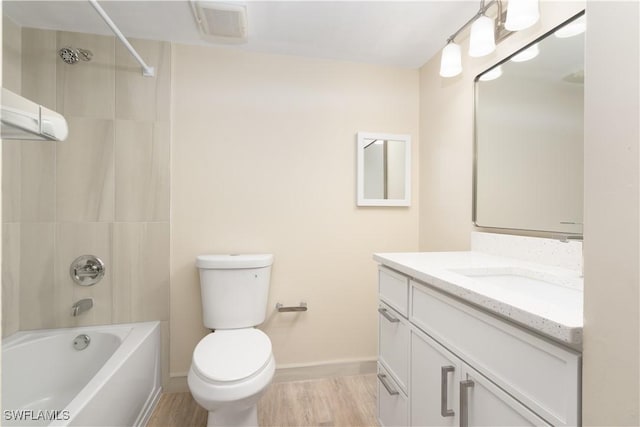 6102 Augusta Dr Unit 315, Fort Myers, FL 33907 - bathroom with wood finished floors, toilet, vanity, baseboards, and washtub / shower combination