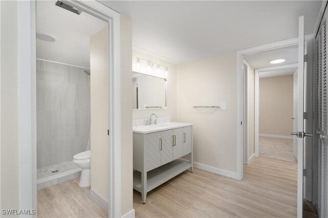 6102 Augusta Dr Unit 315, Fort Myers, FL 33907 - bathroom with wood finished floors, a tile shower, toilet, vanity, and baseboards